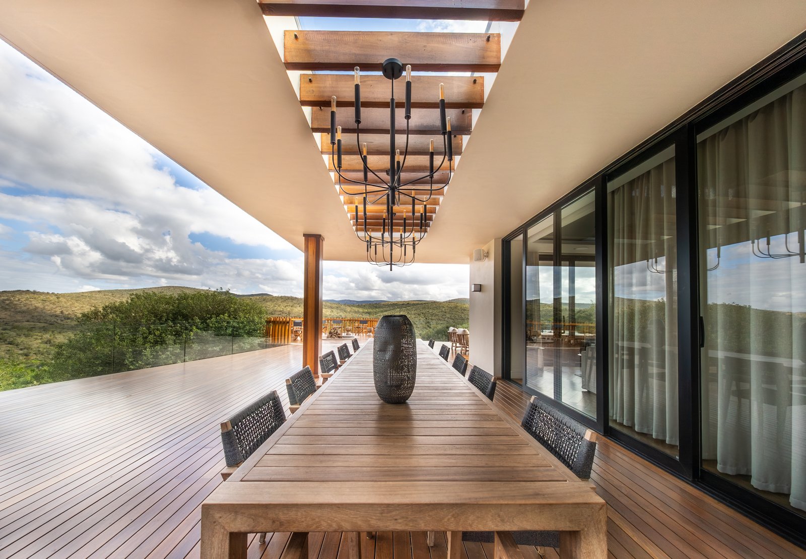 Long table dining on the deck beneath the pergola